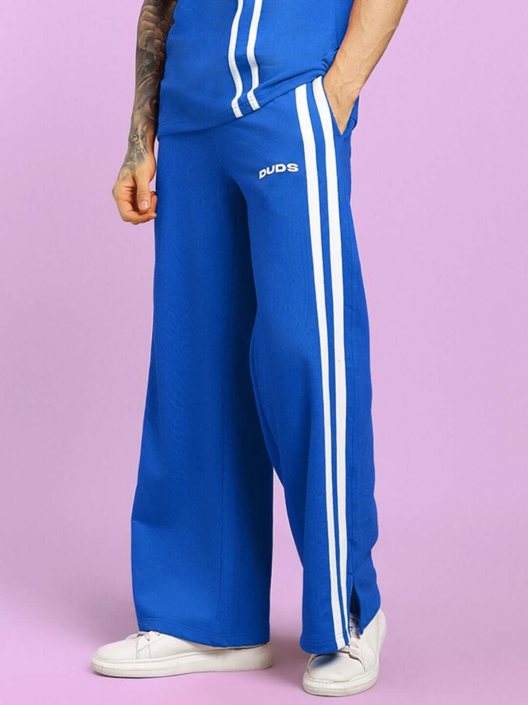 Person wearing blue United Stripe Joggers by DUDS, featuring white stripes, customized fit option available.