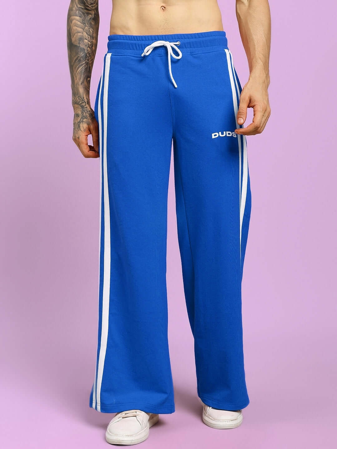 Model wearing blue United Stripe Joggers from DUDS, featuring white stripes, customizable fit, and tailored by experienced tailors.