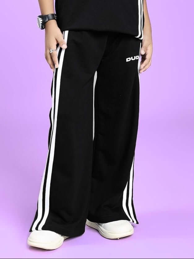Child wearing UNITED STRIPE JOGGER FOR BOYS AND GIRLS BLACK with white stripes on a purple background, showcasing comfort and style.