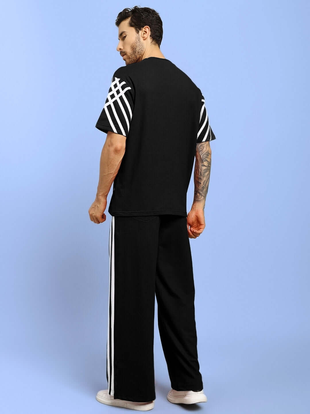 Man wearing black United Stripe Joggers with white stripes, made to order by DUDS, customizable for a perfect fit.