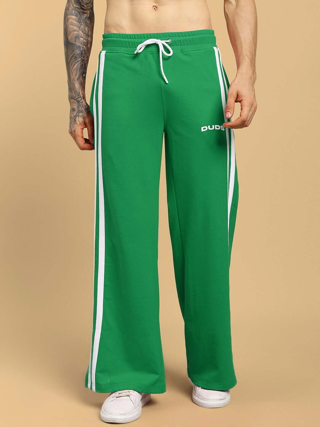 Man wearing green United Stripe Joggers by DUDS with white side stripes and drawstring waist, showcasing casual sporty style.