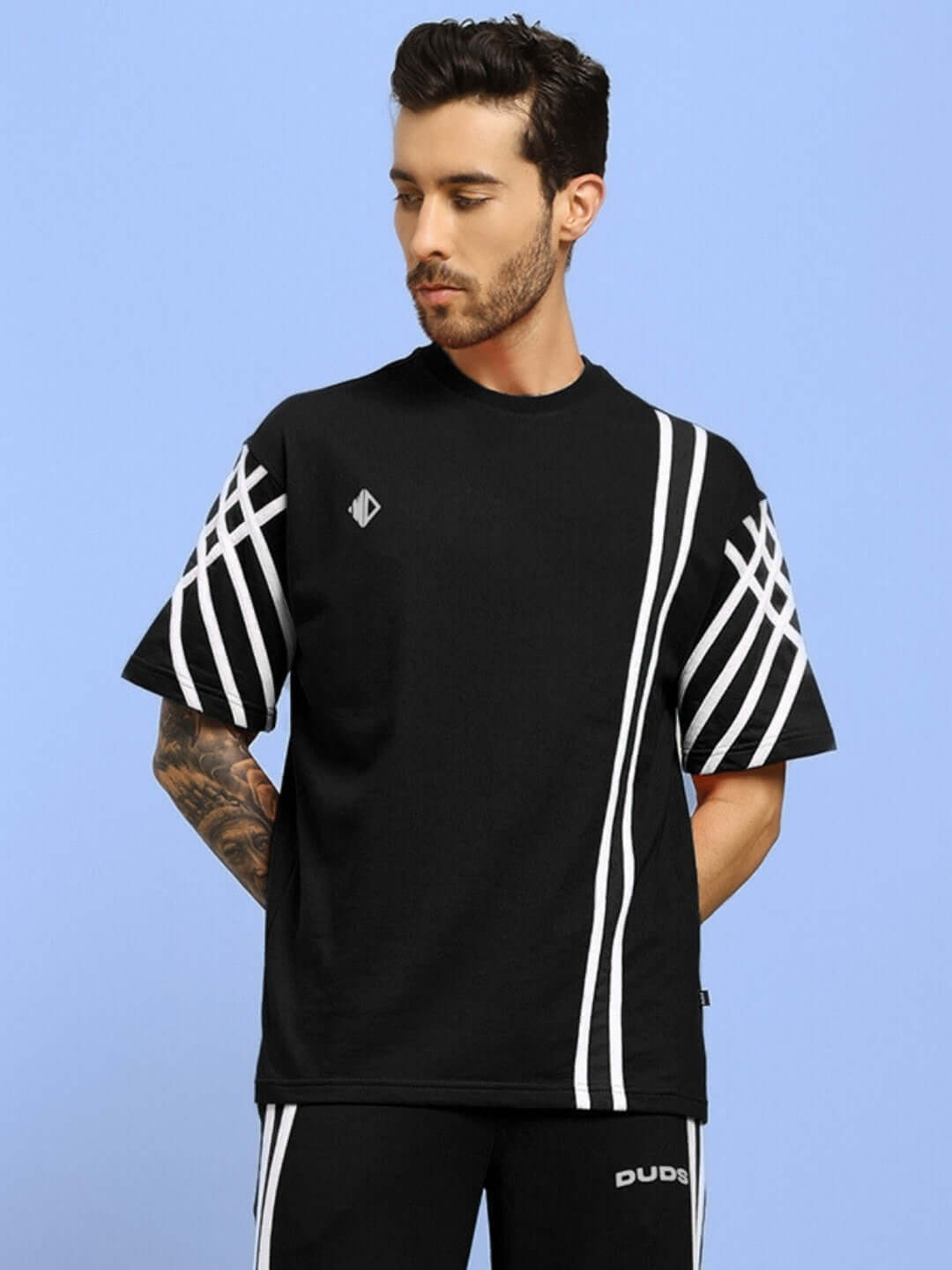 Black oversized t-shirt with white stripes, made from premium cotton French terry and elastane blend, modeled by a man.