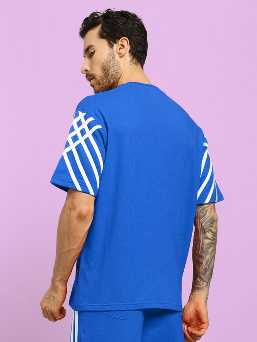 Model wearing United Stripe Over-Sized T-Shirt in blue, premium cotton fabric, displaying stylish striped design on sleeves.