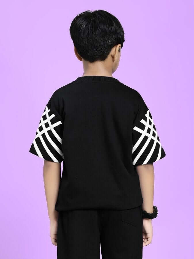 Child wearing UNITED STRIPE T-SHIRT FOR BOYS AND GIRLS BLACK with bold stripe sleeves against purple background