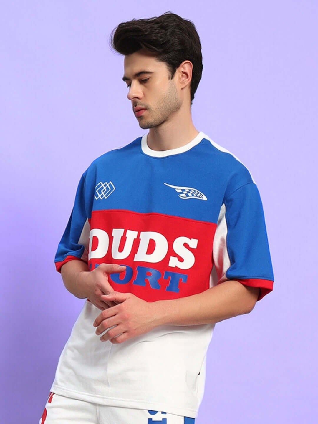 Model wearing URBAN DRIFT OVER-SIZED T-SHIRT MULTI in blue, red, and white on a purple background.