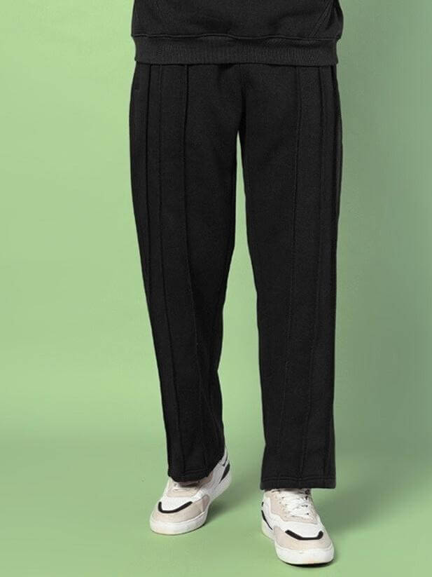 URBAN FLEECE CARGO PANTS BLACK with sleek design, showcasing modern streetwear fashion on a green background.