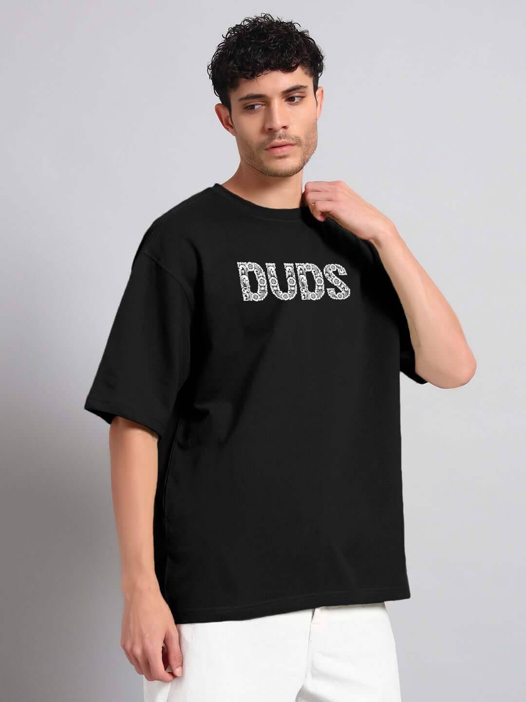 Model wearing Urban Petal oversized black t-shirt with bold print, made from premium cotton fabric. Stylish casual wear from India.
