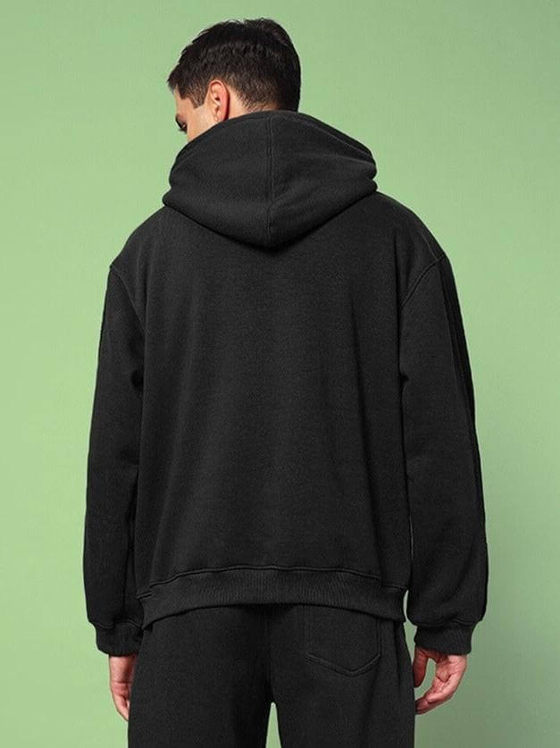 Back view of model wearing URBAN SOLID PLATED FLEECE HOODIE BLACK, showcasing its sleek and minimal design with roomy hood.