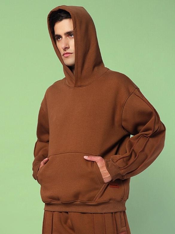 Model wearing URBAN SOLID PLATED FLEECE HOODIE BROWN with hands in pockets.