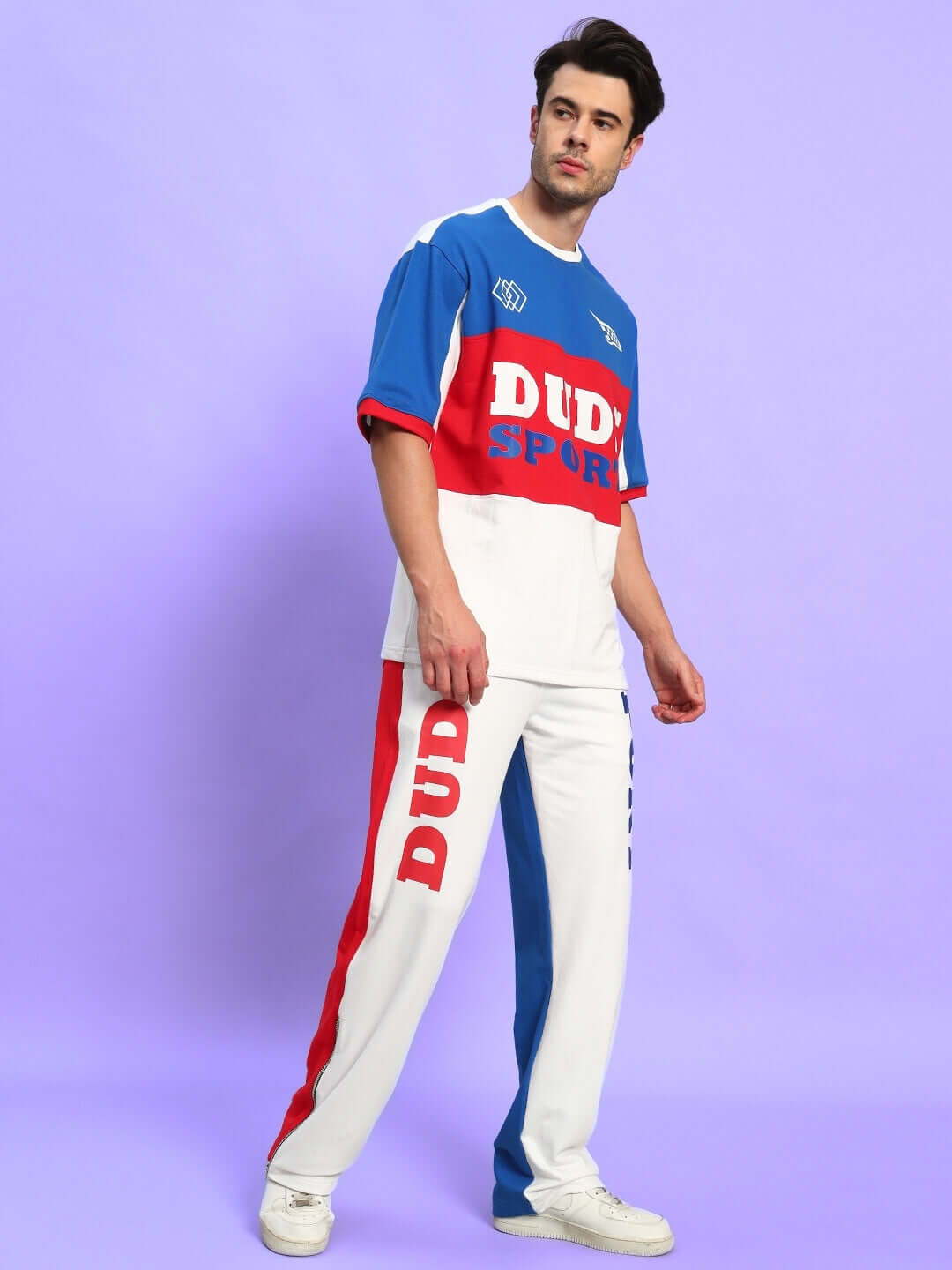 Model wearing Urban Drift Relaxed Fit Co-Ord Set Multi, vibrant streetwear outfit, blue and red colors, perfect for casual outings and travel.