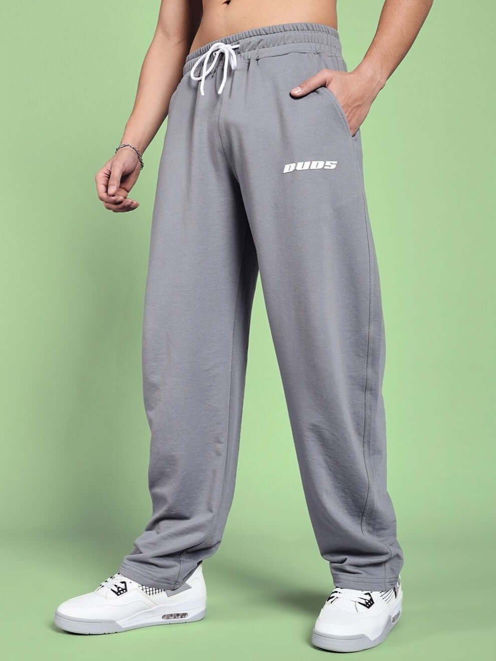 Model wearing grey vanilla relaxed-fit joggers by DUDS, showcasing comfortable fit and style. Made-to-order with custom sizing option.