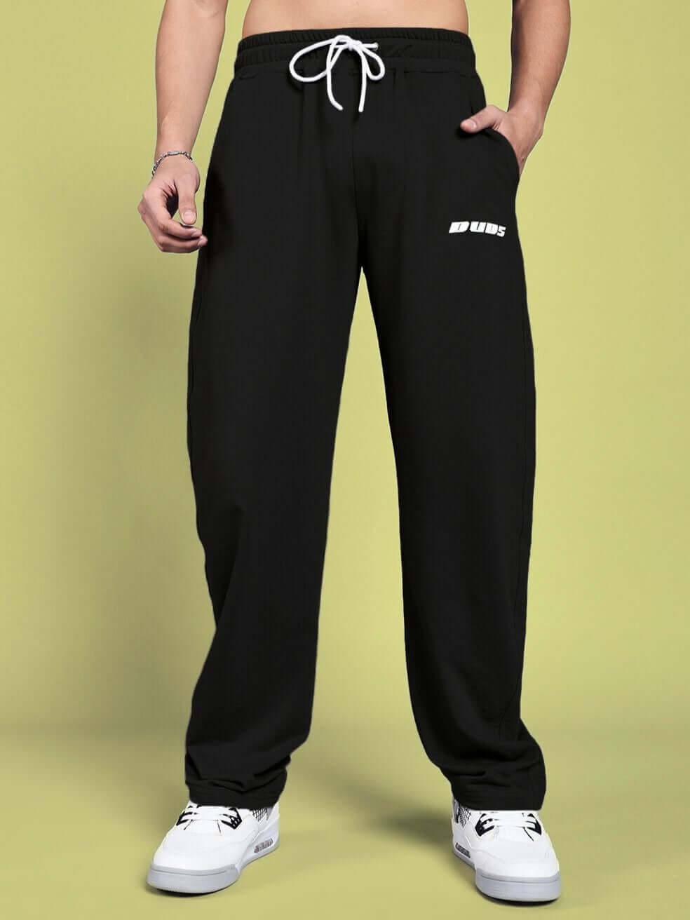 Man wearing DUDS Vanilla Relaxed-Fit Joggers in black, showcasing adjustable drawstring waist and casual fit, paired with white sneakers.