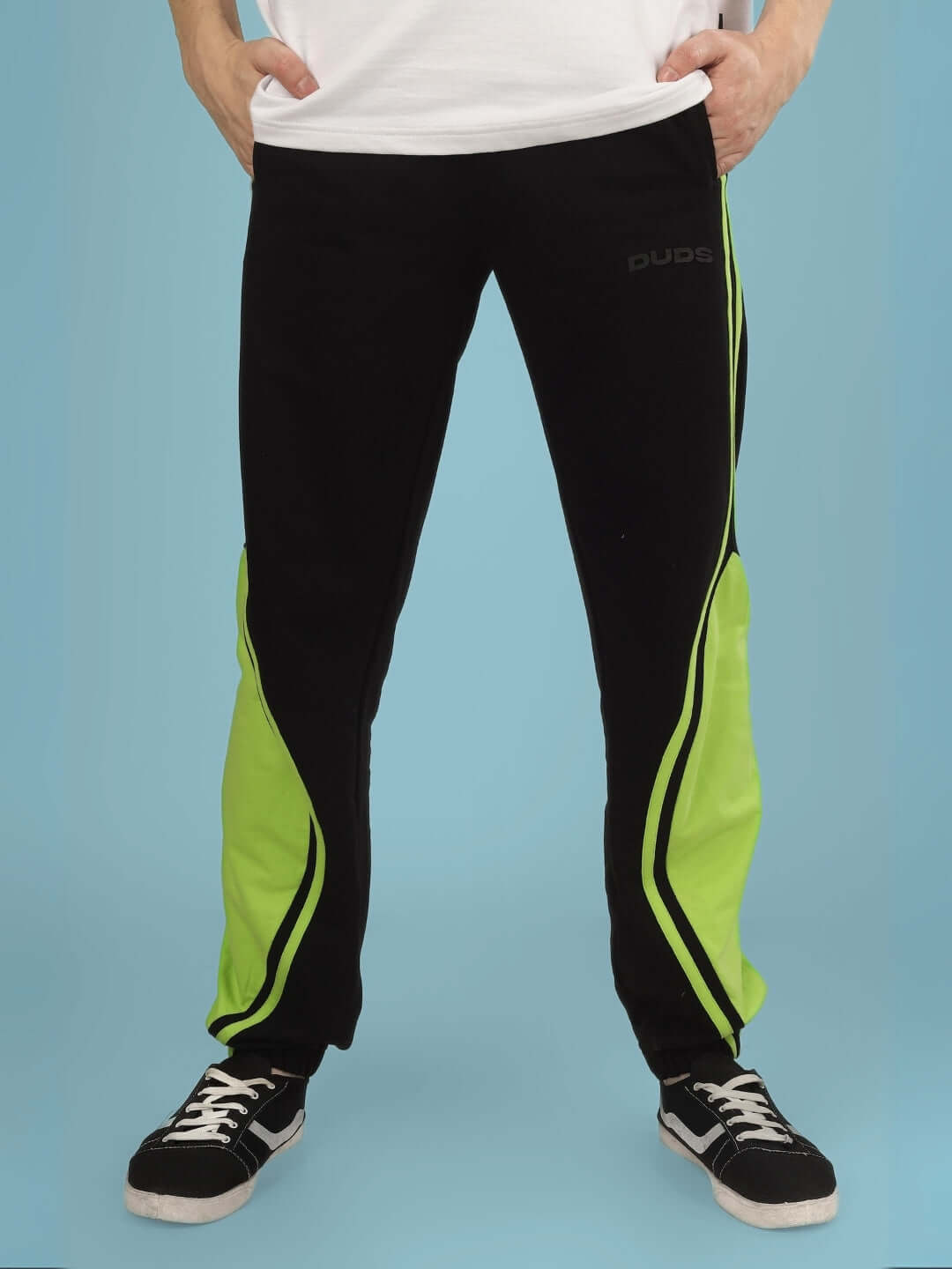 Man wearing VECTOR BAGGY JOGGERS in black and neon green, made to order by DUDS with customizable fit options.