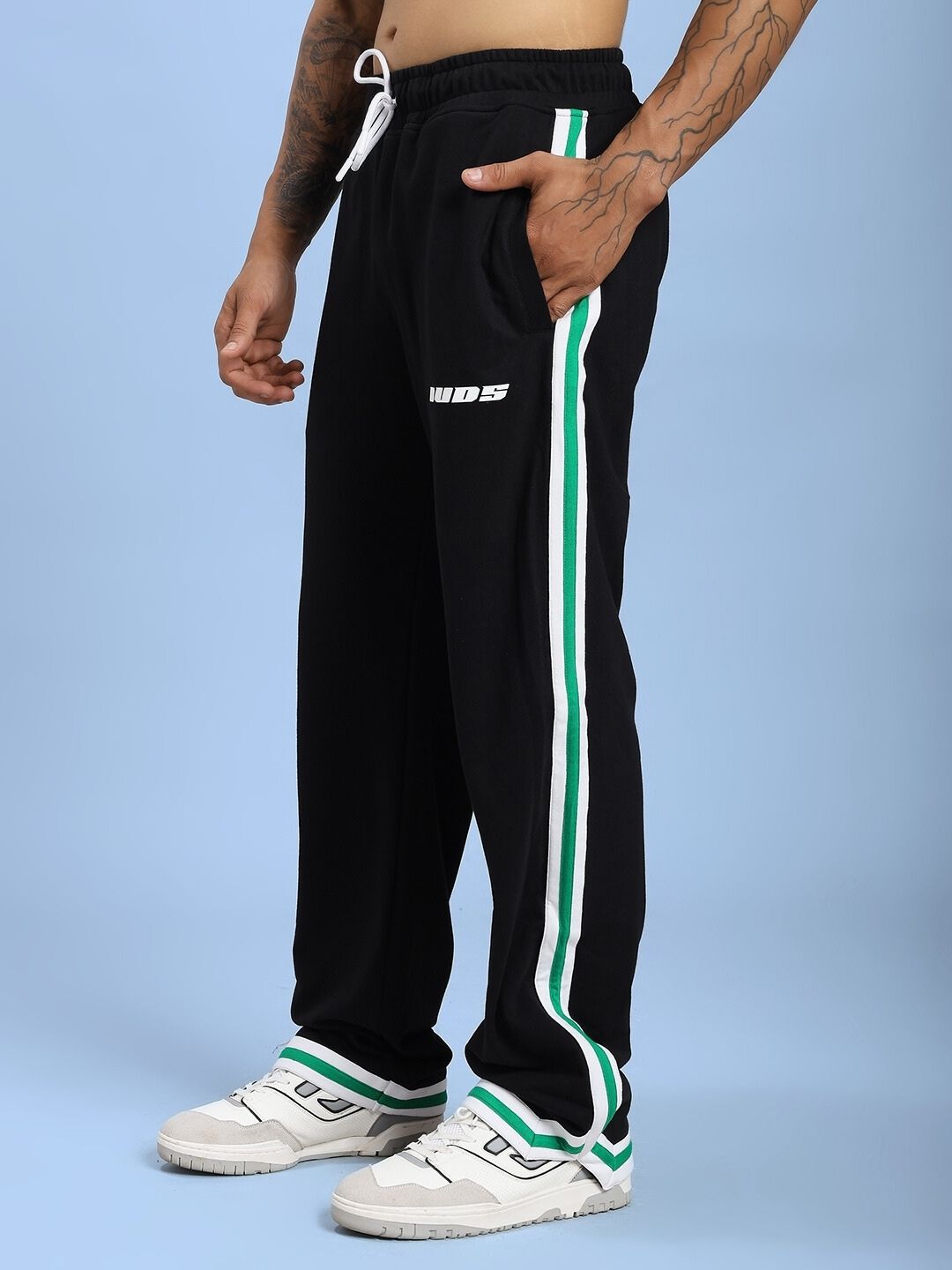 Man wearing VELO GREEN STRIPE RELAXED FIT JOGGER BLACK with green stripe detail.