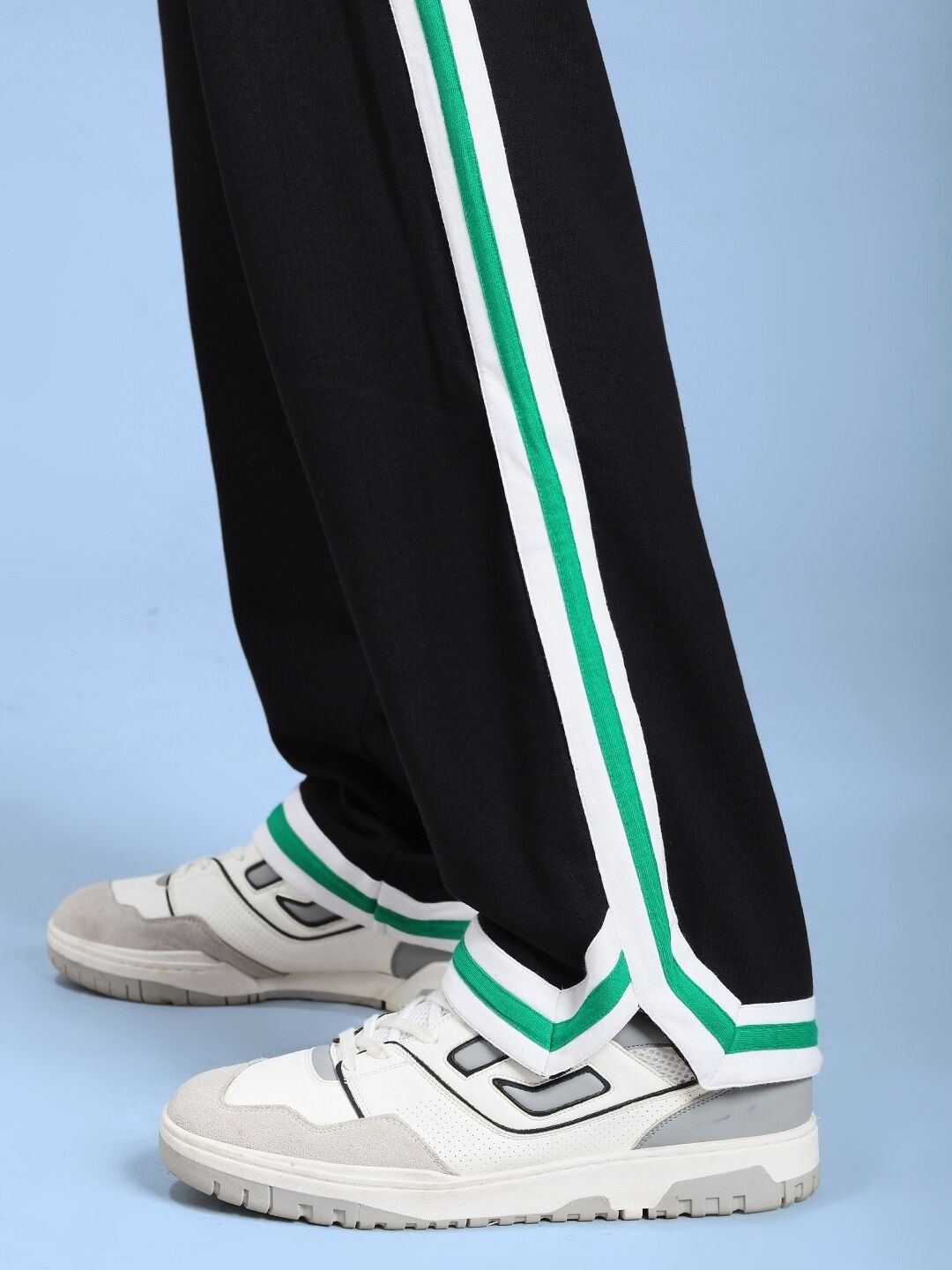 Model wearing VELO GREEN STRIPE RELAXED FIT JOGGER BLACK with sneaker, showcasing green stripe detail.