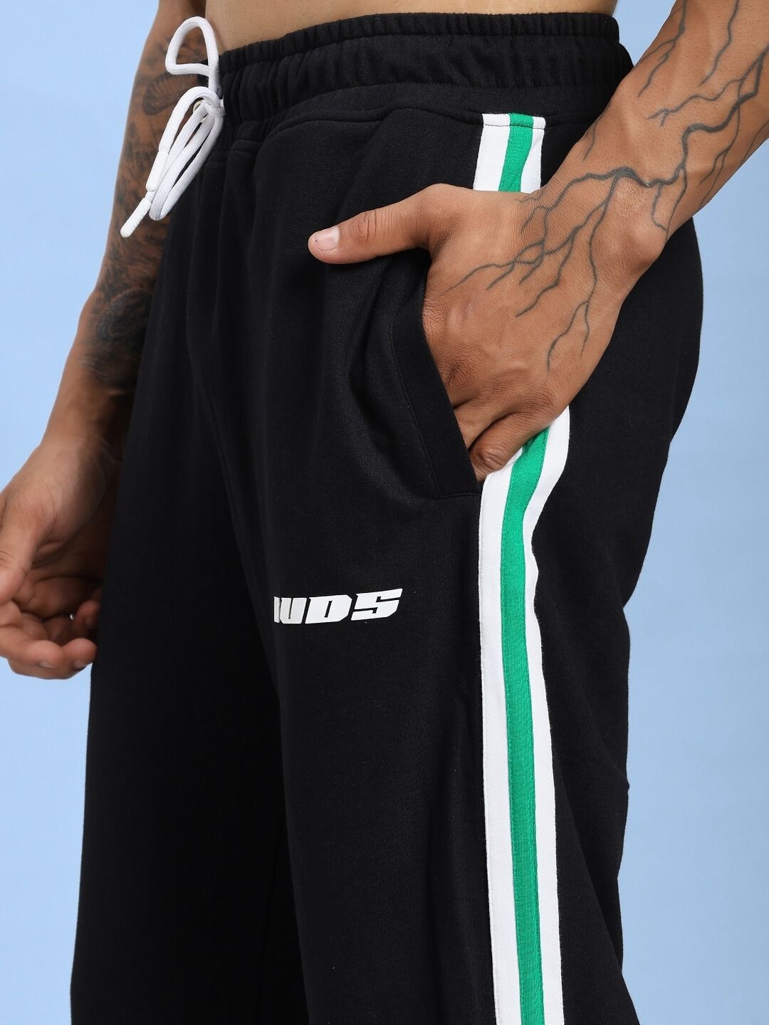 Close-up of VELO GREEN STRIPE RELAXED FIT JOGGER BLACK with green stripe detail on the side, showcasing comfort and style.
