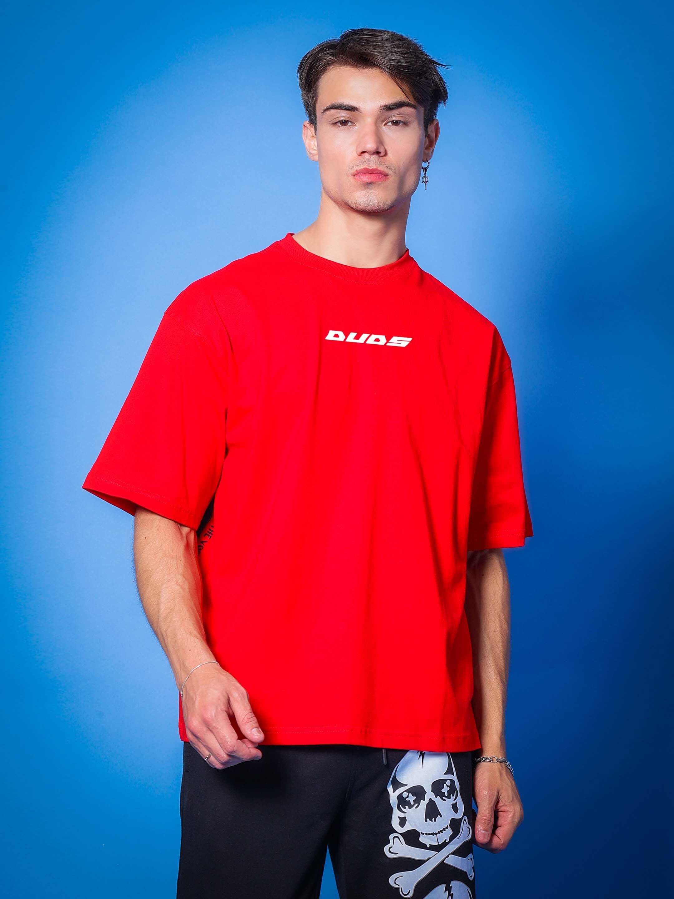 Model wearing Victory oversized red t-shirt from DUDS, showcasing skull-patterned black pants. Custom fit options available for prepaid orders.
