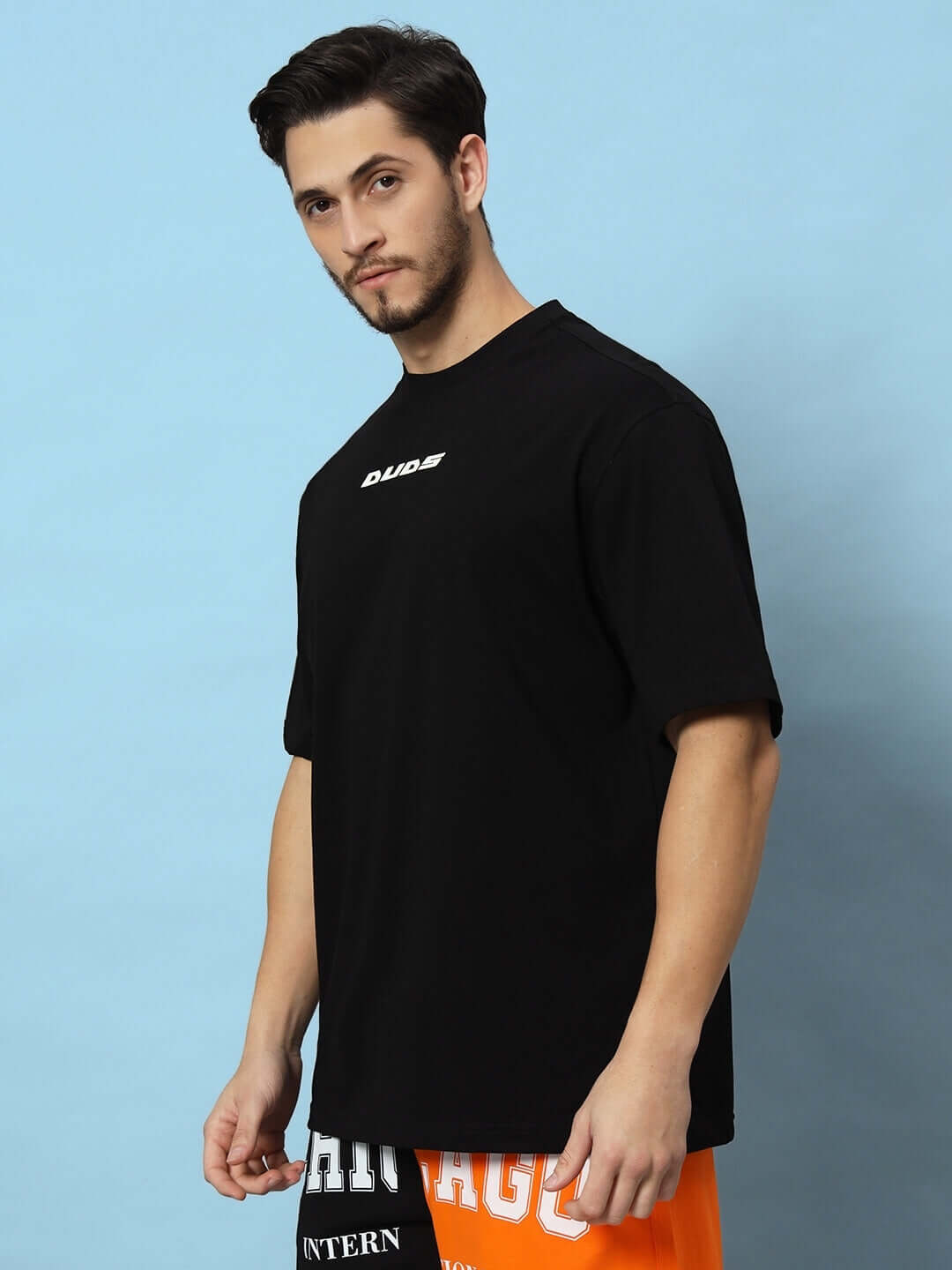 Model wearing black VICTORY OVER-SIZED T-SHIRT by DUDS; available in Custom Fit for prepaid orders, handmade with dedication.