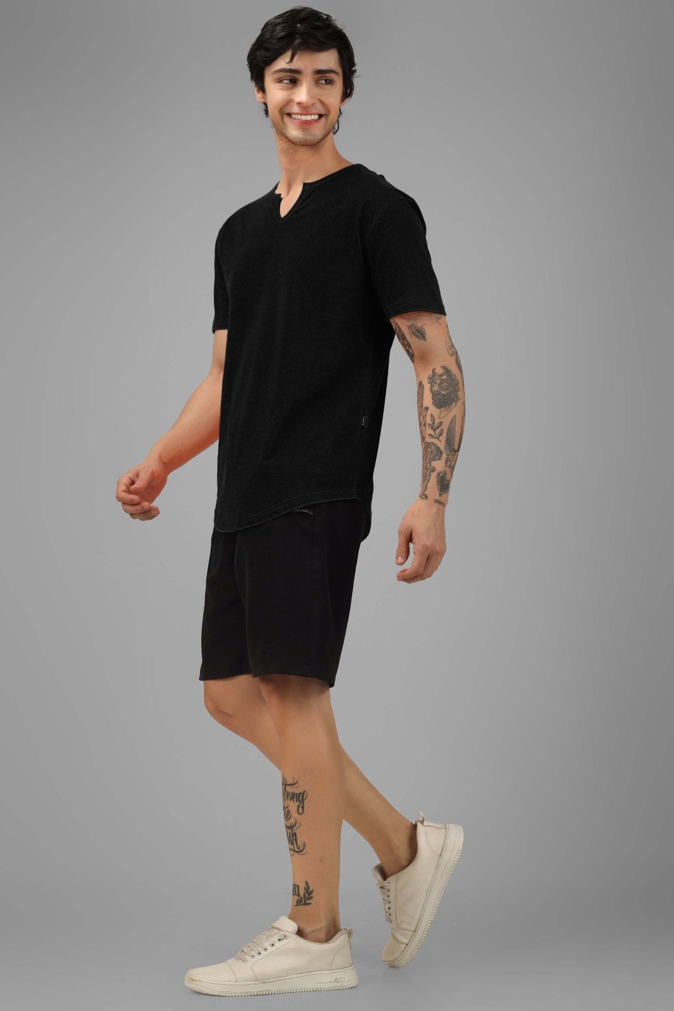 Model wearing VIKING REGULAR FIT T-SHIRT BLACK, showcasing casual style with tattoos and white sneakers.