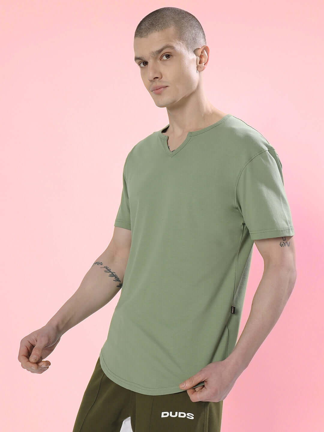 Model wearing Viking regular fit sage green T-shirt made of premium 100% cotton fabric, standing against a pink background.