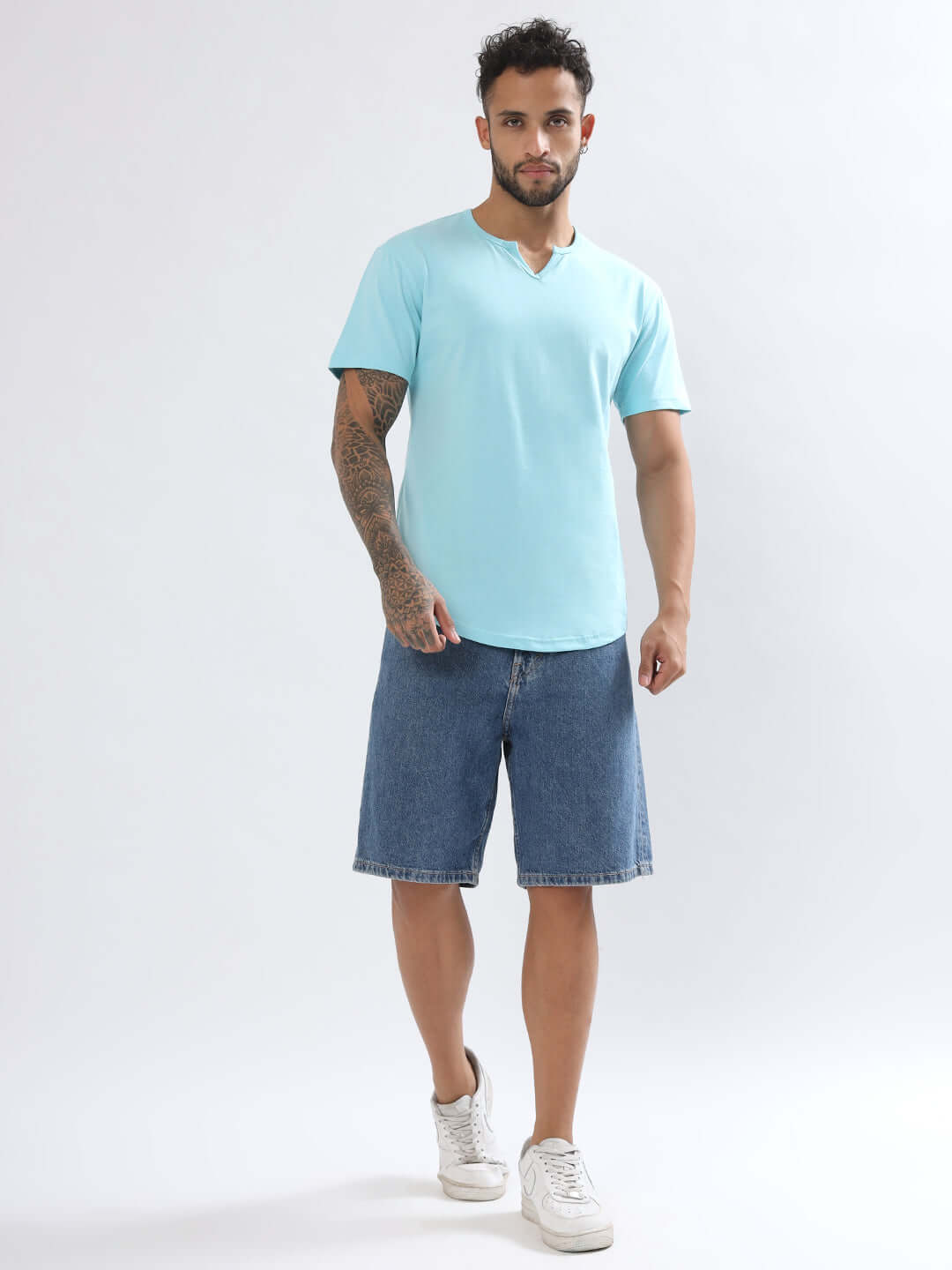 Man wearing Viking Regular Fit Sky Blue T-Shirt, paired with denim shorts and white sneakers, showcasing casual style fashion.