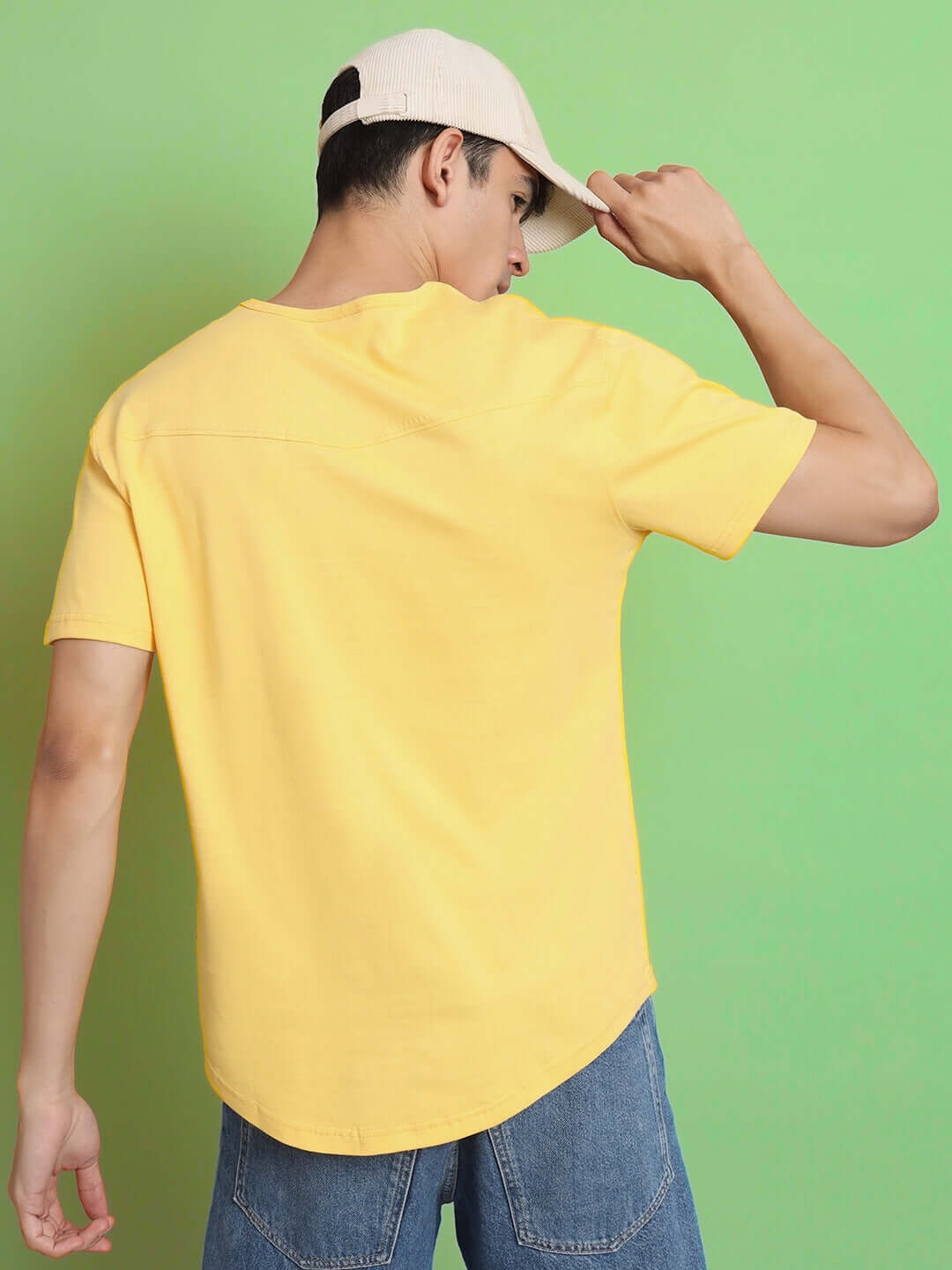Back view of a man wearing a yellow Viking regular fit t-shirt and jeans against a green background, showcasing premium 100% cotton fabric.