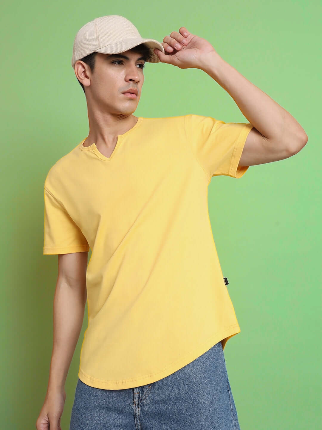 Model wearing Viking regular fit yellow T-shirt, 100% cotton, styled casually with blue jeans against a green background.