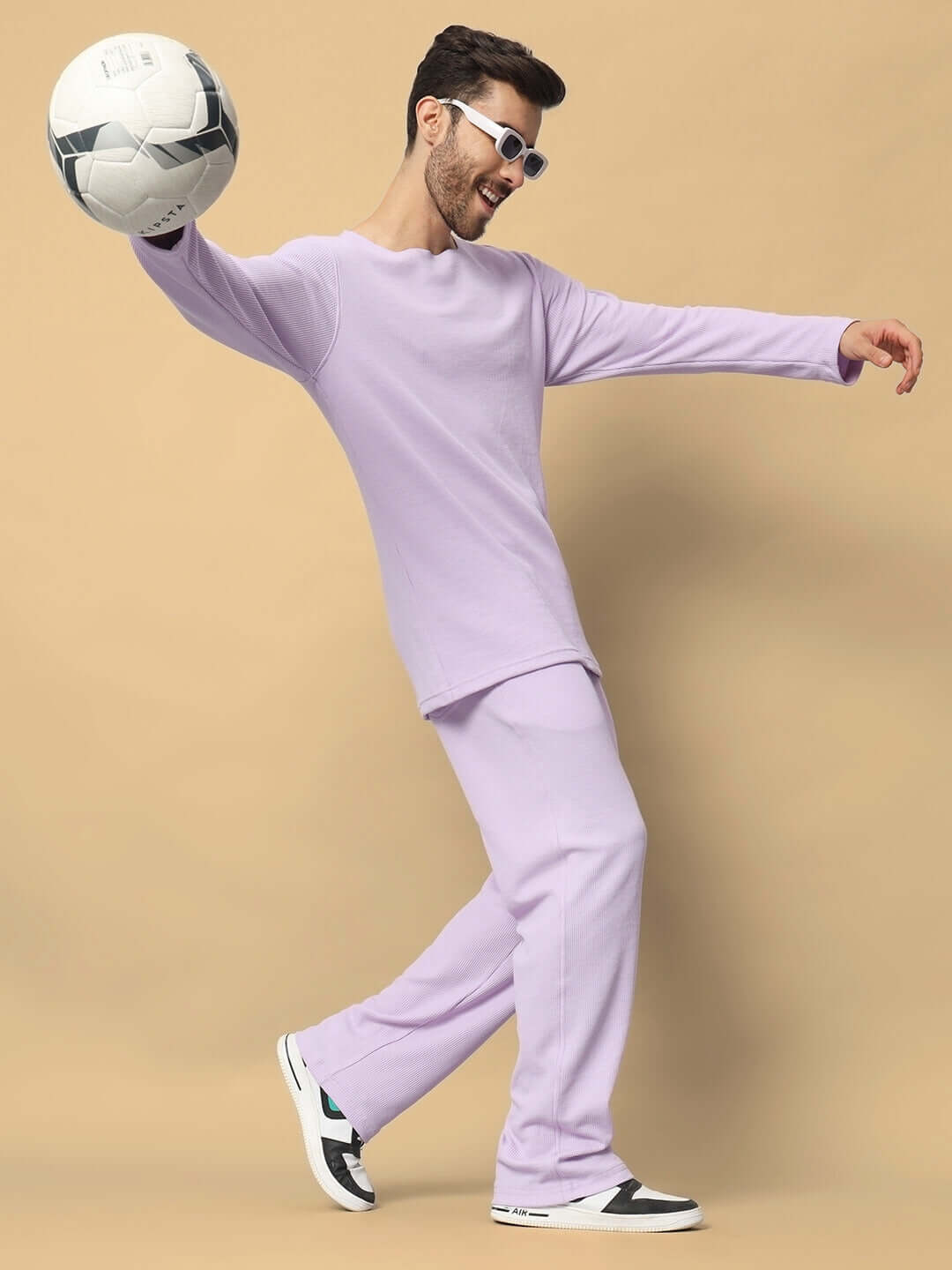 Unisex lilac co-ord set, relaxed fit with joggers and top, premium waffle fabric, sporty style, model holding a soccer ball.