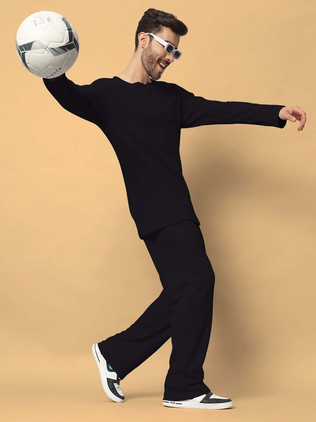 Unisex Vogue oversized black co-ord set with relaxed fit joggers, holding a soccer ball, made from 100% cotton waffle fabric.