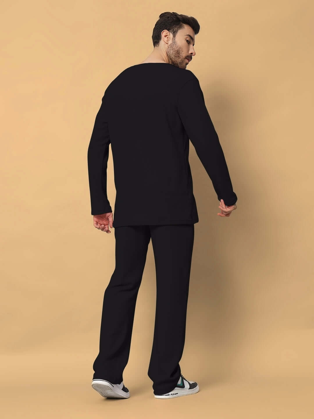 Man wearing Vogue Oversized Co-Ord Set in black, featuring unisex relaxed fit joggers and elasticated waistband for a customizable fit.
