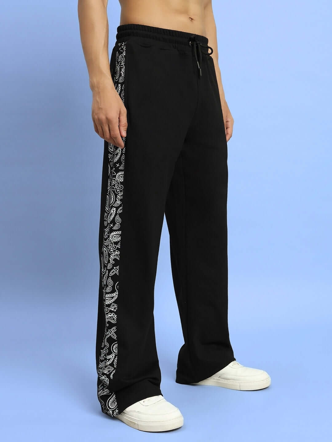Model wearing WALTZ relaxed fit black joggers with patterned side panels, featuring a loose fit and drawstring waist.