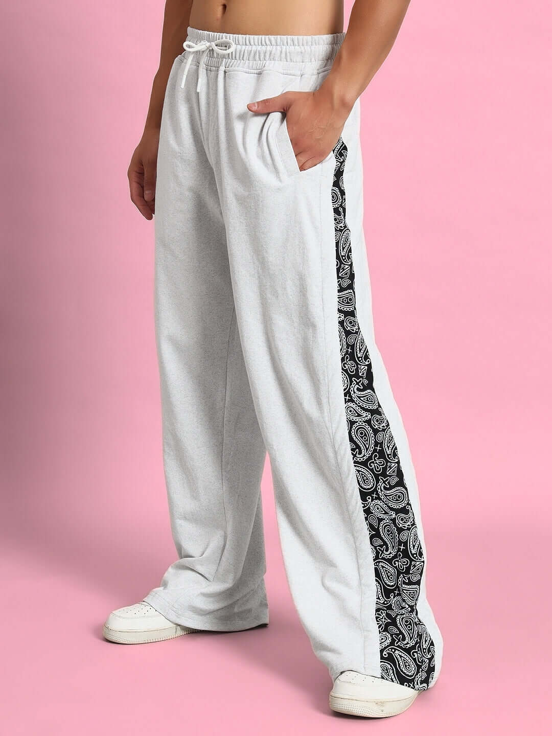 Male model wearing Waltz Relaxed Fit Joggers in melange grey with patterned side stripe, shown against a pink background.