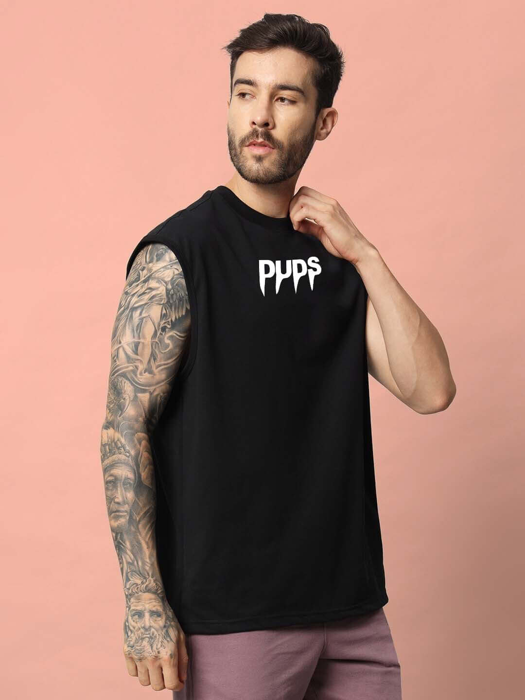 Man wearing black sleeveless gym t-shirt with 'PYPS' logo and tattooed arm, stylish activewear fashion.