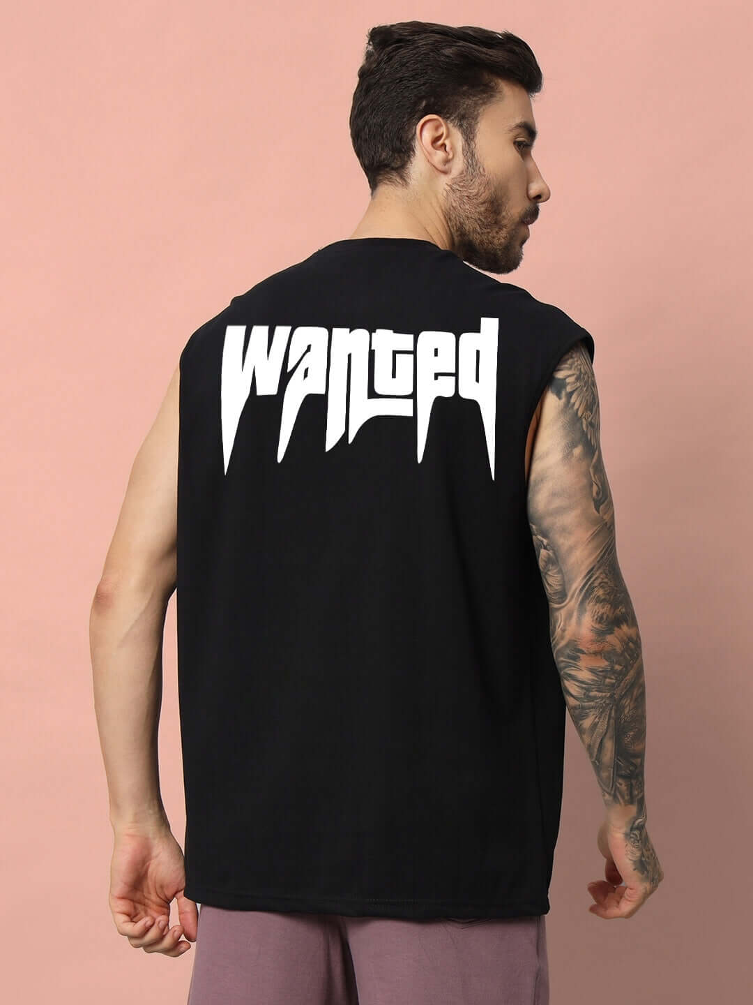 Rear view of man wearing black "WANTED" gym t-shirt, showcasing unique design and comfortable fit.