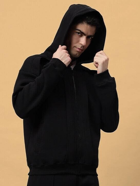Man wearing WD ADMIRE COTTON FLEECE HOODIE BLACK with hood up, showcasing the stylish oversized fit and kangaroo pocket.