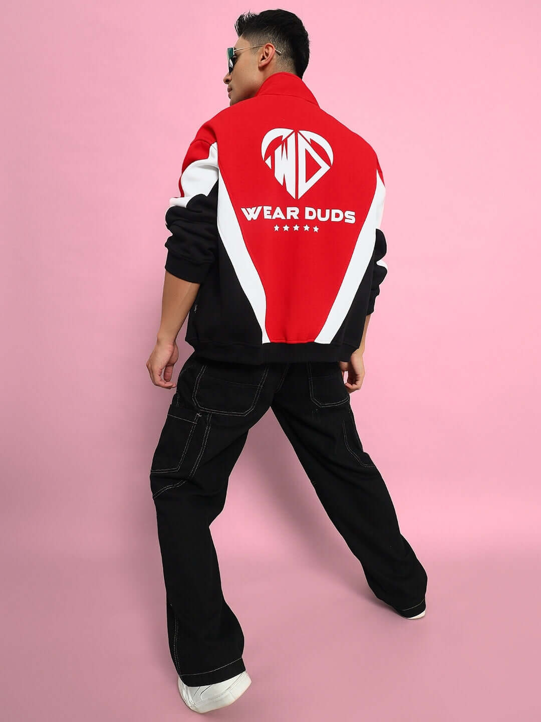 Man wearing WD ALFA colorblock jacket in red, black pants, posing against pink background.