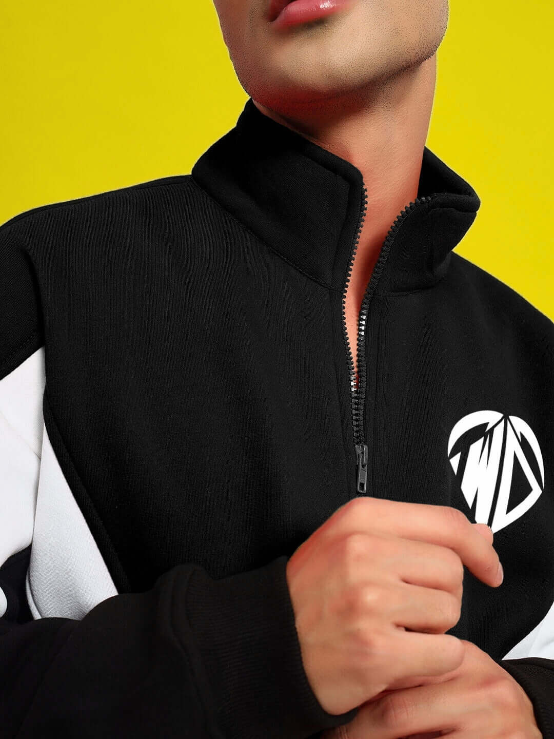 Person wearing WD ALFA Fleece Colorblock Jacket in black with logo, close-up on zipper, made by DUDS. Custom fit available.
