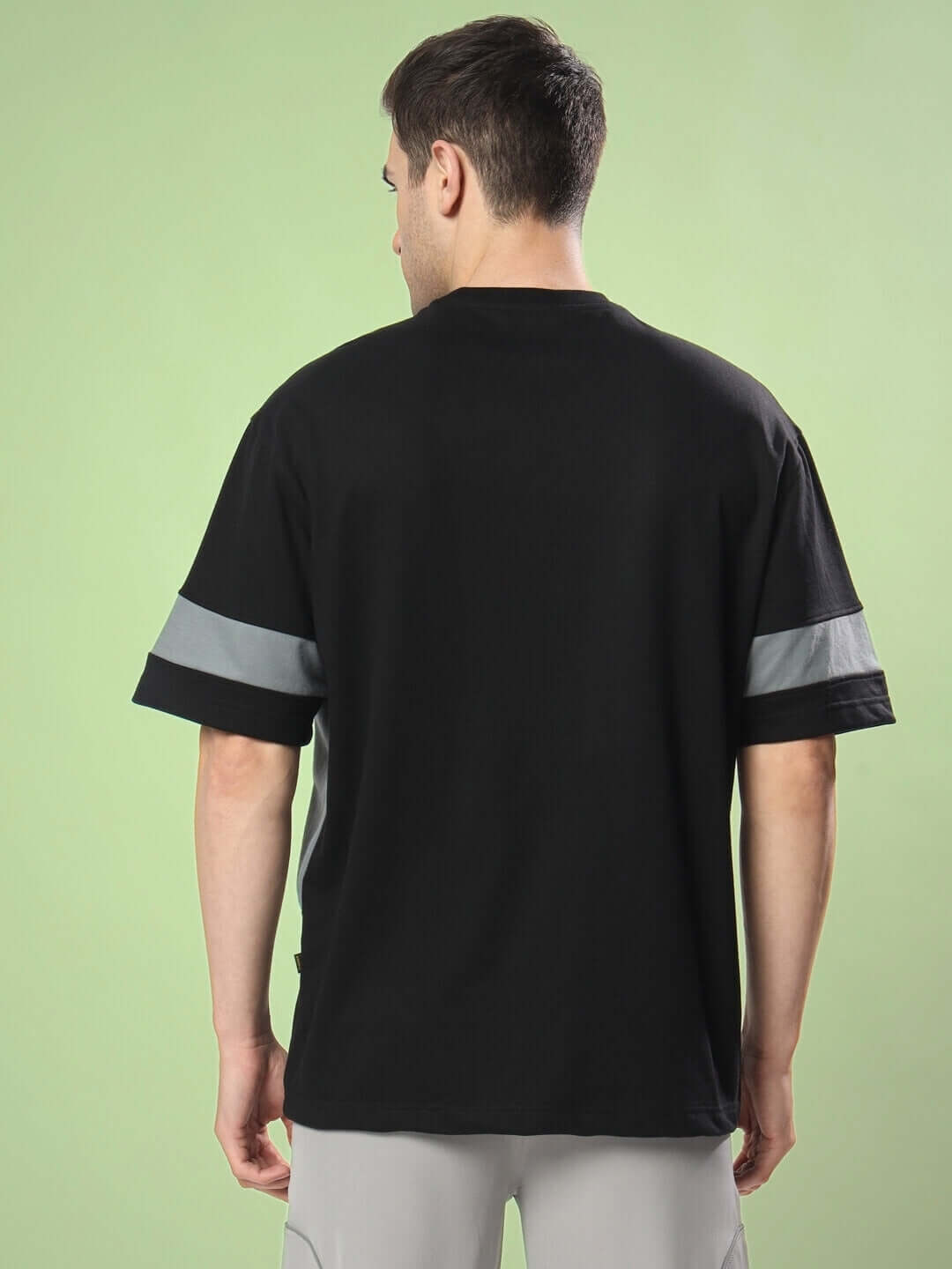 Back view of black-grey WD GORBCORE oversized t-shirt on model, made from premium cotton and elastane, showcasing a stylish design.