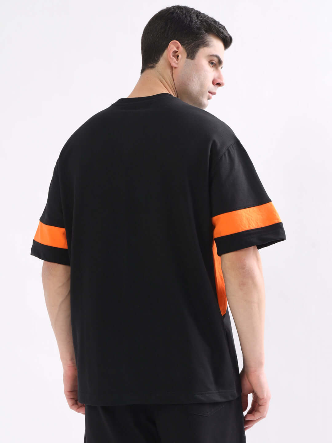 Model wearing WD Gorpcore Oversized Black-Orange T-Shirt, showing back details, made of premium cotton blend fabric from India.