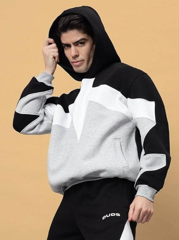 Model wearing WD Sword colorblock co-ord in black-grey, showcasing stylish hoodie and pants from DUDS. Custom fit available.