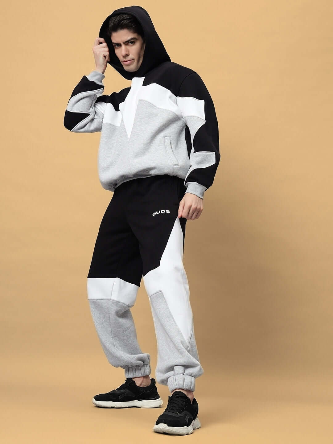 Model wearing WD Sword Fleece Colorblock Cargo Pant with black and white panels, showcasing streetwear style and cozy comfort.