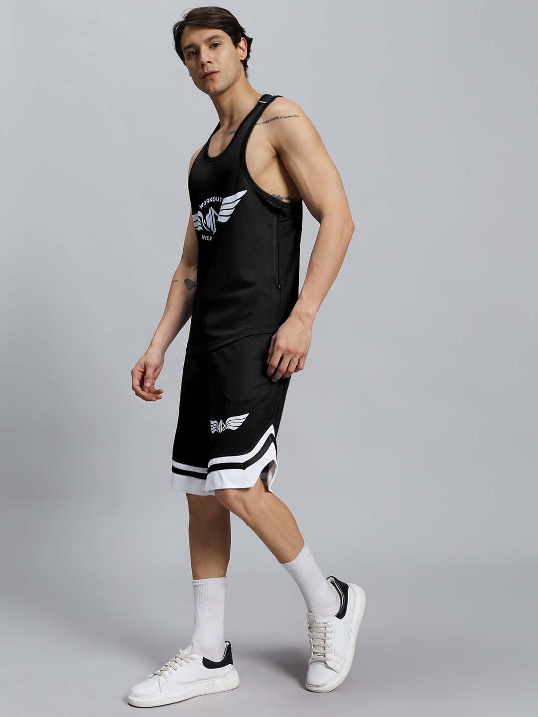 Man wearing WD WINGS GYM CO-ORD SET MEN BLACK, showcasing athletic fit and wing detailing, perfect for stylish workouts.