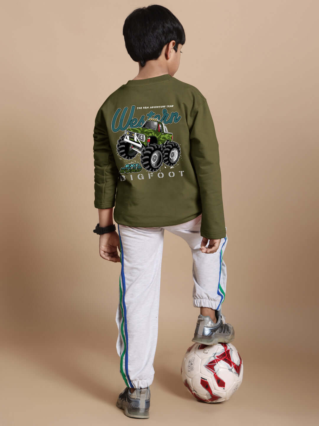 Child wearing olive green Western truck oversized sweatshirt with a massive truck graphic, standing with a soccer ball, premium cotton fabric.
