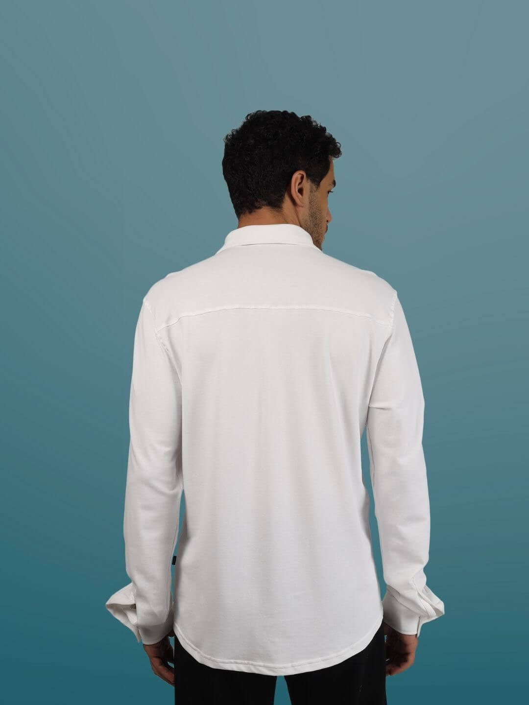 Back view of a white sporty pique shirt, featuring full sleeves, curved hem, and wrinkle-free fabric. Perfect for all-day comfort.
