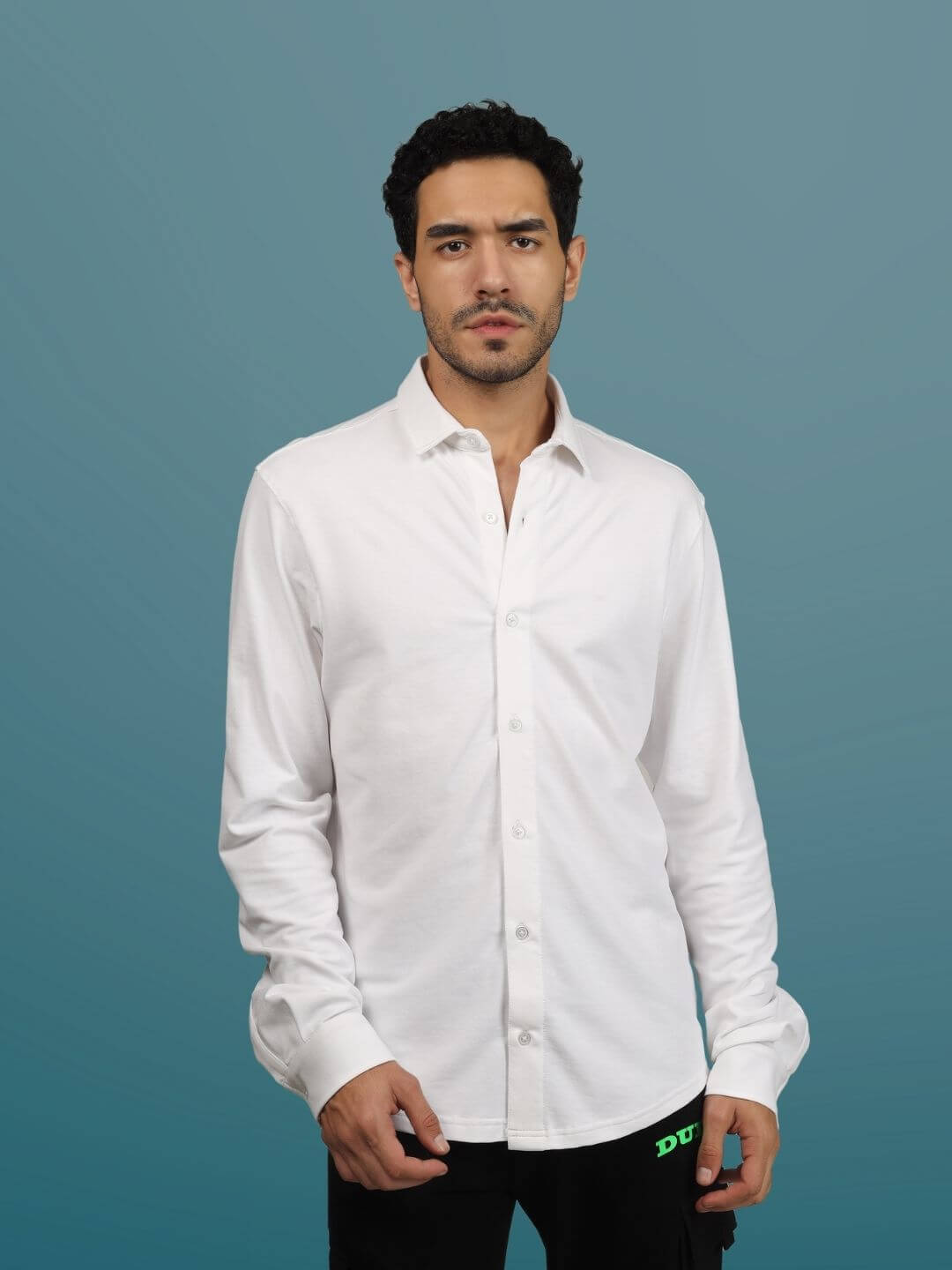 Model wearing a white sporty pique shirt with full sleeves and a slim fit design against a blue background.