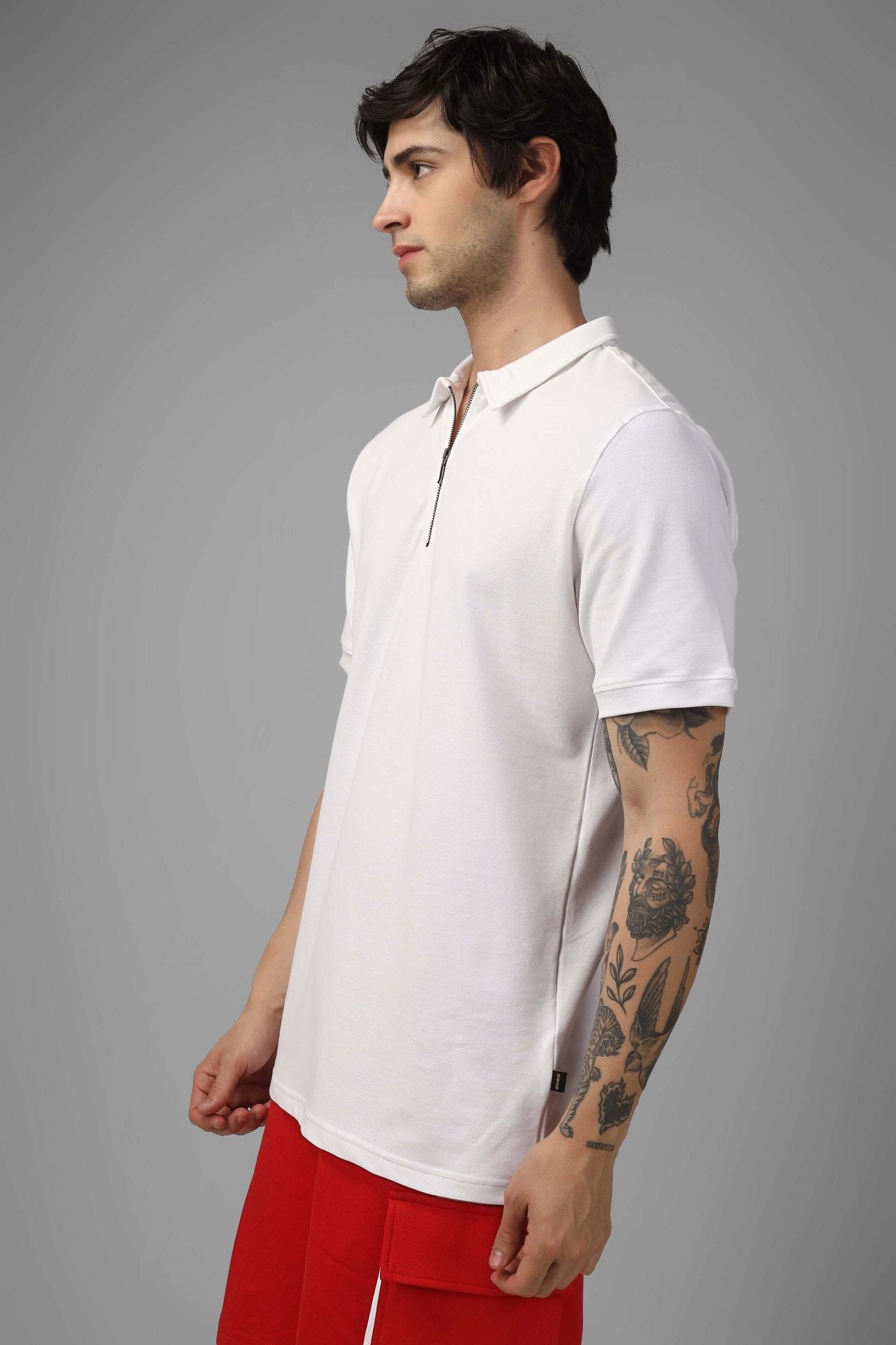 Model wearing ZIPPER POLO NECK COTTON T-SHIRT WHITE with tattooed arms, featuring a sleek zipper and crisp white finish.
