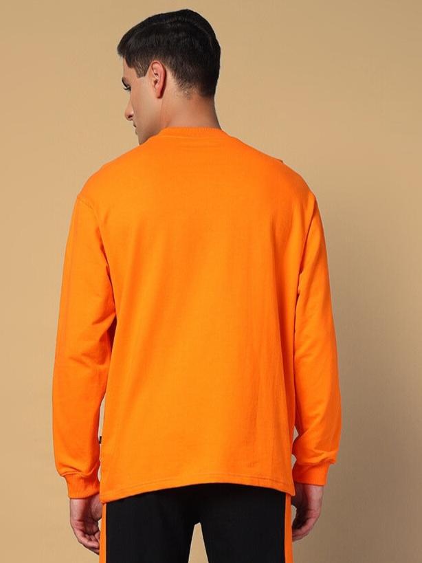 Back view of man wearing orange WHOPPER oversized sweatshirt, made from premium cotton French terry, showcasing its vibrant color and fit.