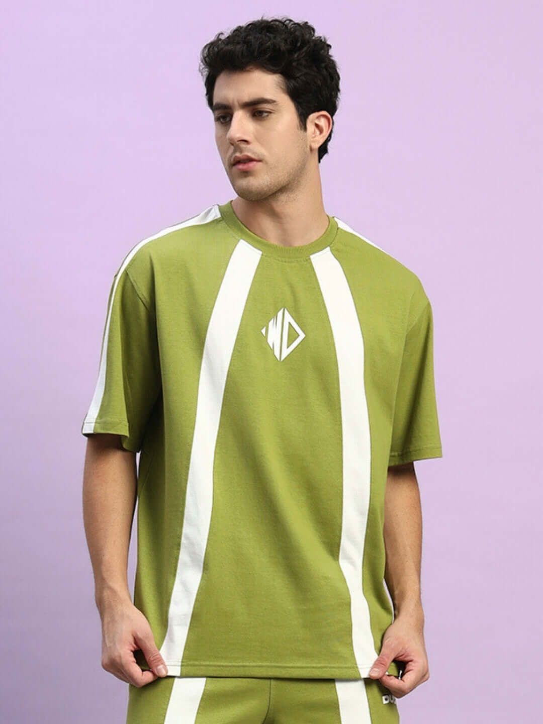 Model wearing WIDELINE OVER-SIZED T-SHIRT OLIVE GREEN made from premium heavy gauge fabric with white stripes.