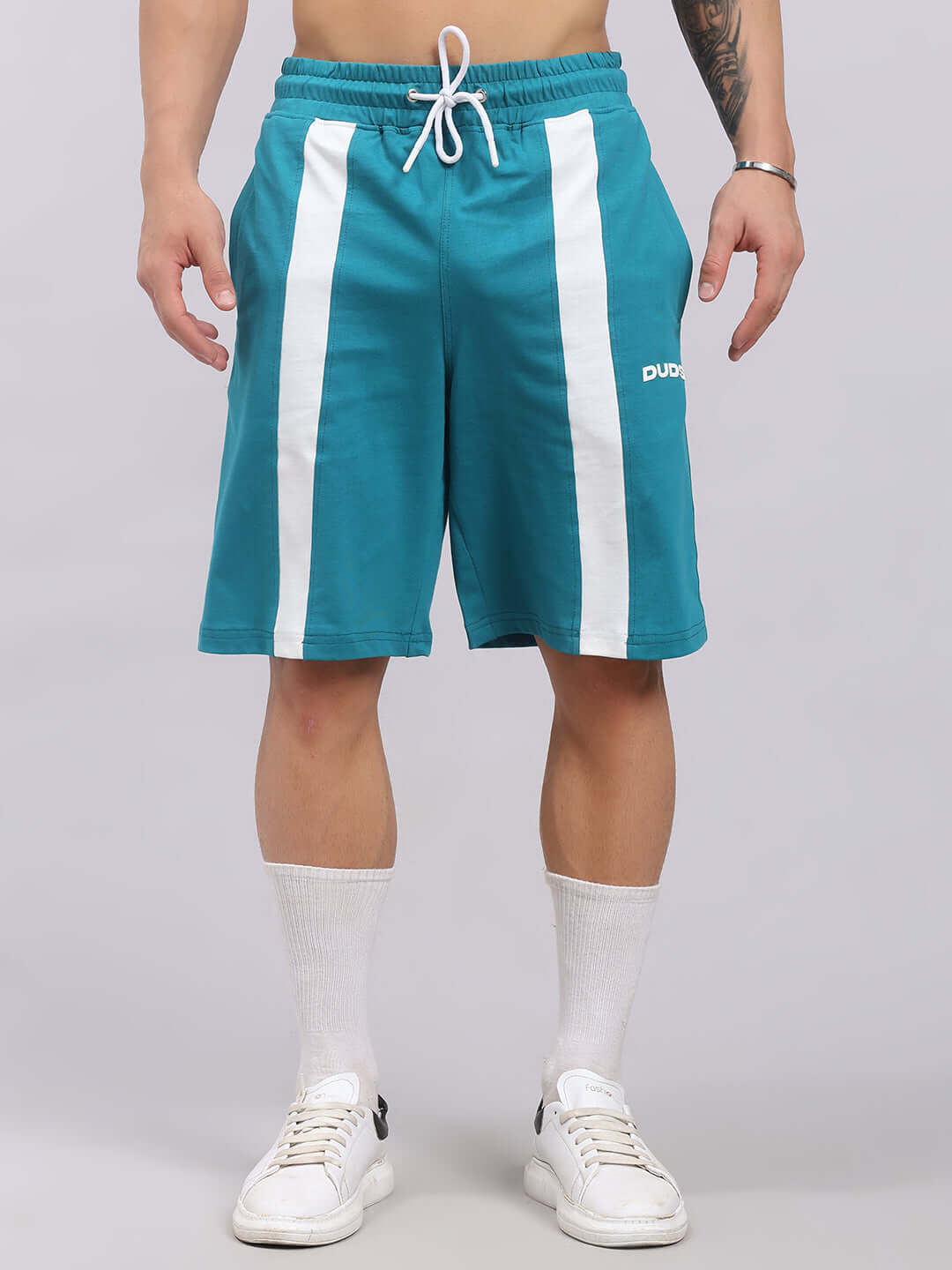 Man wearing Wideline Regular Fit Shorts Teal with white stripes, designed for comfort and style in casual settings.