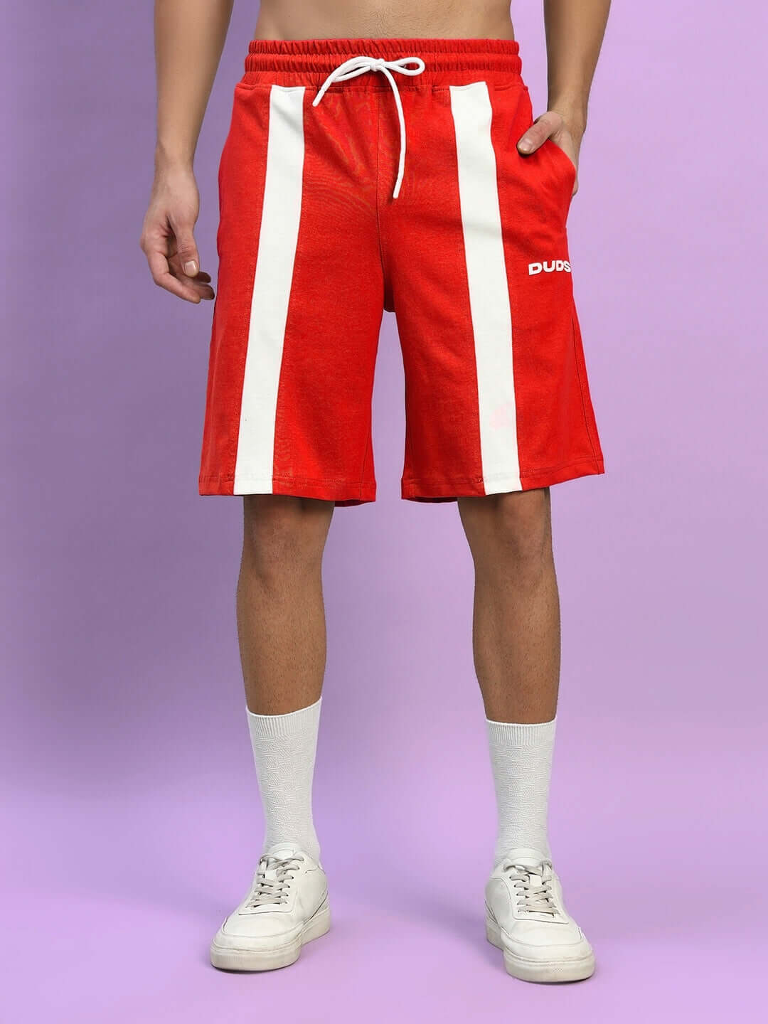 Red WIDELINE regular fit shorts with white stripes, customizable size option, worn on a model against a purple background for DUDS.